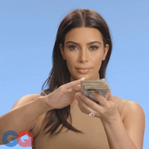 GIF: Kim Kardashian with a wad of cash brushing notes away from her