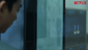 GIF: Squid Game Player appears with an envelope in his hand saying "one more round"